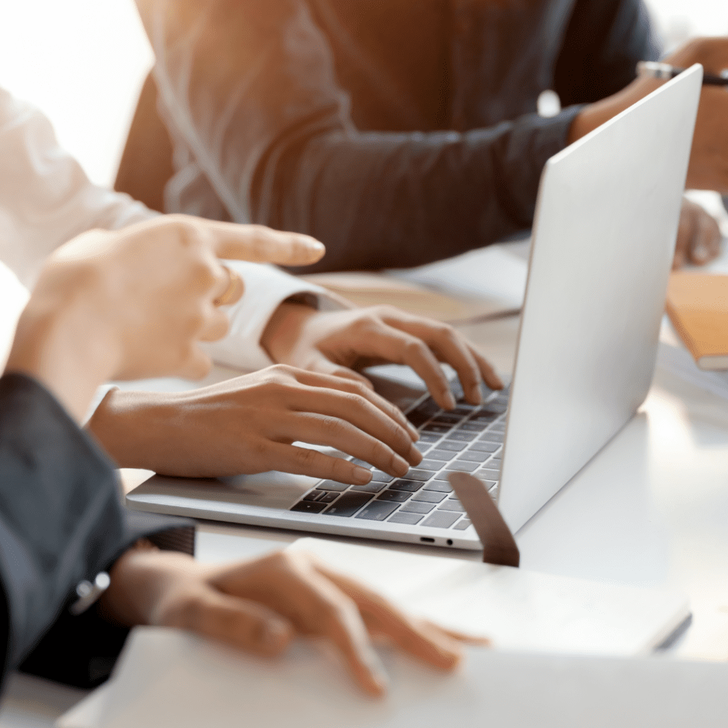 Woman typing on laptop in a meeting