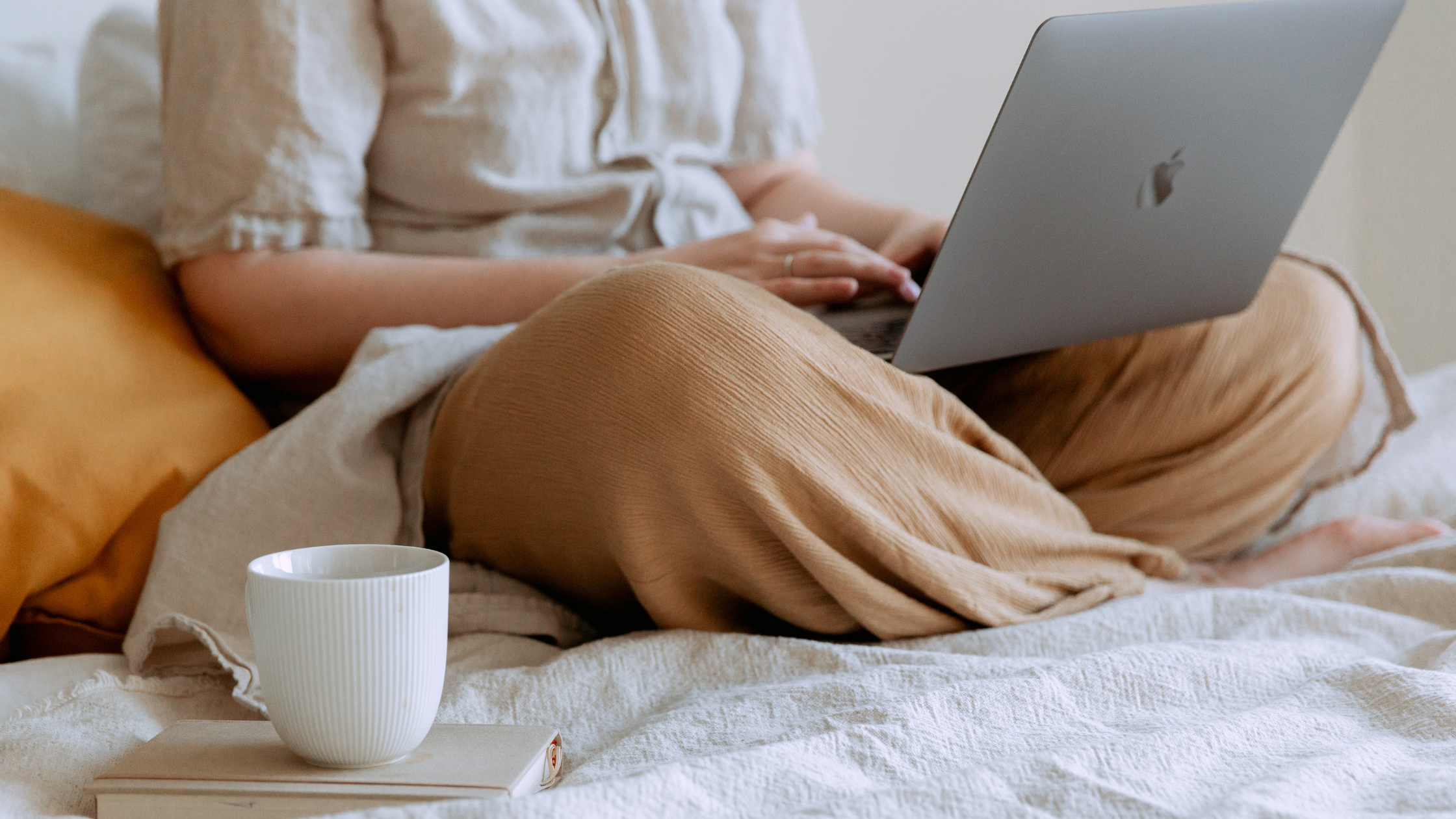 Woman sitting on bed with an laptop