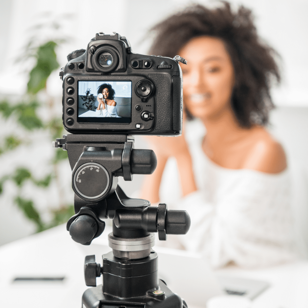 Still photo of a woman shooting a video with a camera