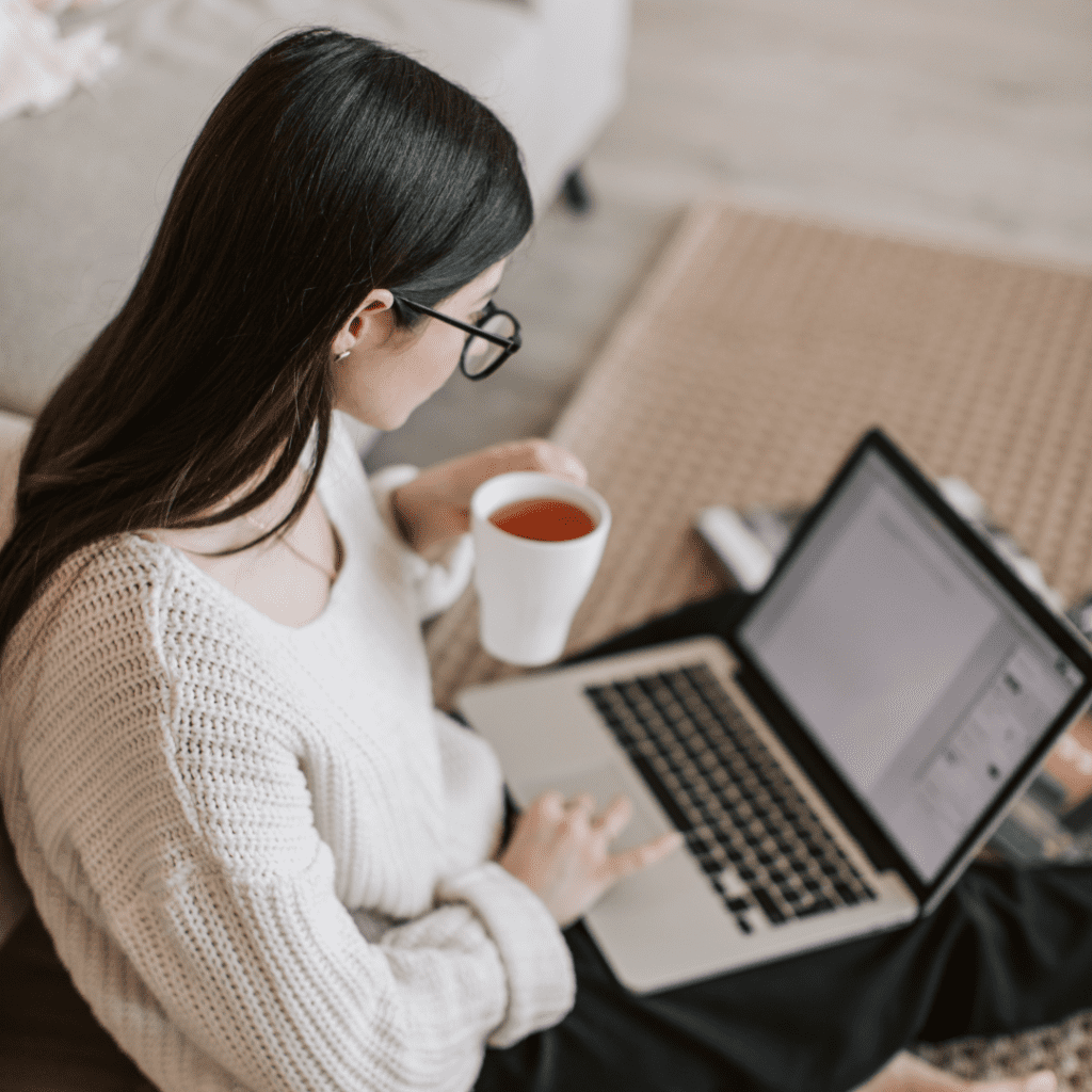 Woman on laptop with coffee in hand. Schedule your appointment today