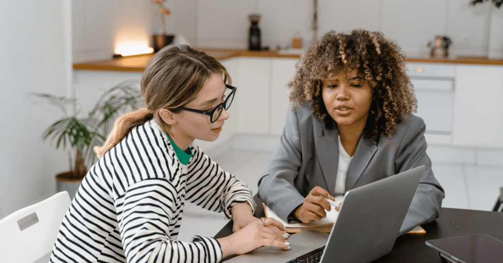 Two women working on a laptop together